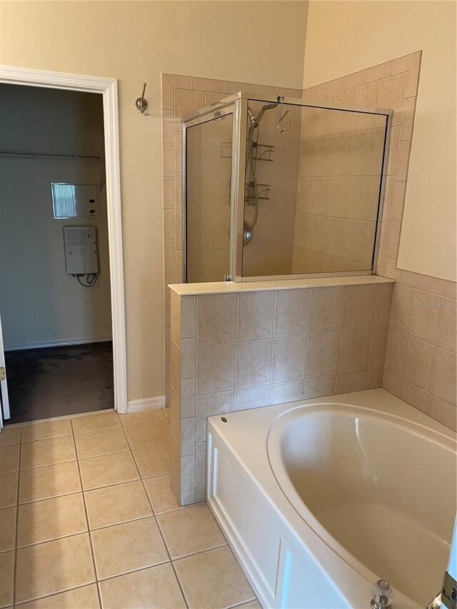 bathroom featuring a stall shower, tile patterned flooring, and a bath