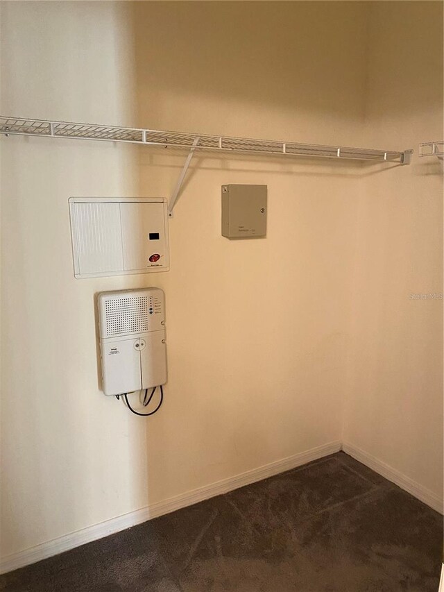 laundry area with carpet floors and baseboards