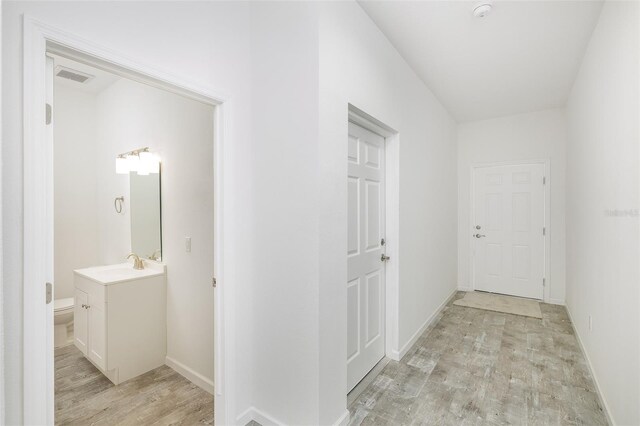 hallway featuring sink and light wood-type flooring