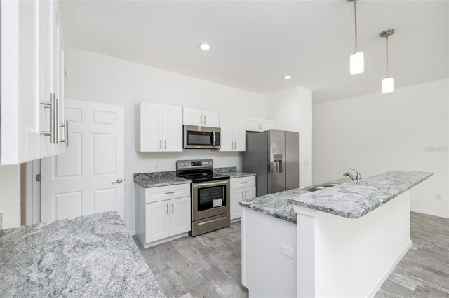 kitchen with stainless steel appliances, white cabinets, light stone counters, and decorative light fixtures