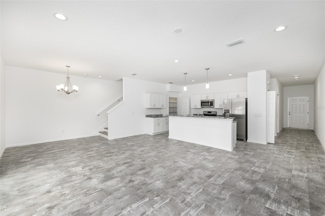 kitchen with pendant lighting, white cabinets, a center island, light hardwood / wood-style floors, and stainless steel appliances