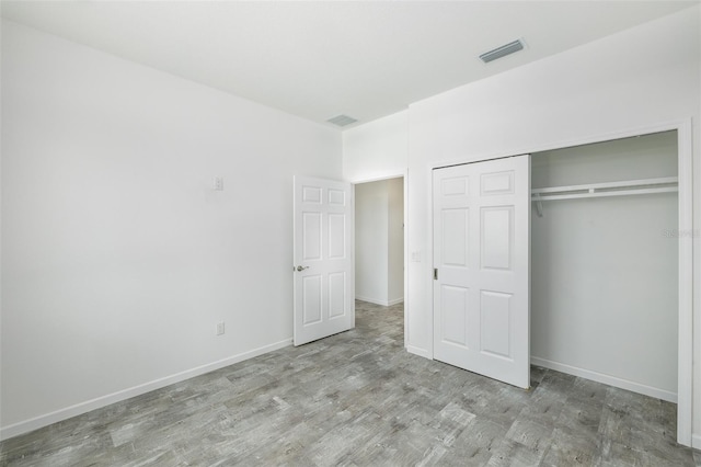 unfurnished bedroom featuring a closet and light hardwood / wood-style flooring