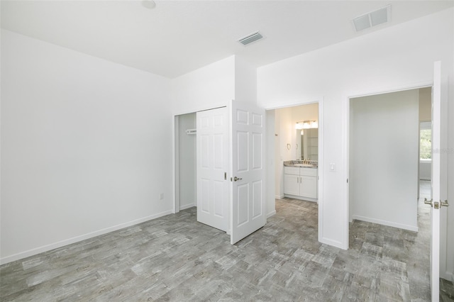 unfurnished bedroom with sink and a closet