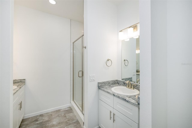 bathroom featuring a shower with door, vanity, and wood-type flooring