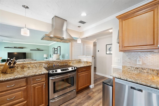 kitchen with appliances with stainless steel finishes, wood-type flooring, island exhaust hood, hanging light fixtures, and ornamental molding