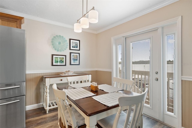 dining area featuring dark hardwood / wood-style flooring, wood walls, and crown molding