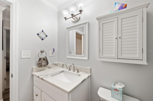 bathroom featuring toilet, crown molding, and vanity