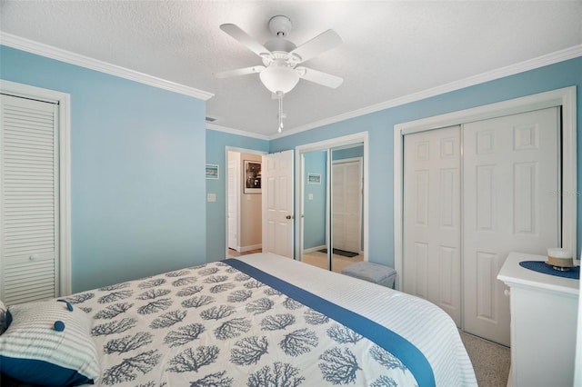 bedroom featuring a textured ceiling, two closets, light carpet, ceiling fan, and crown molding