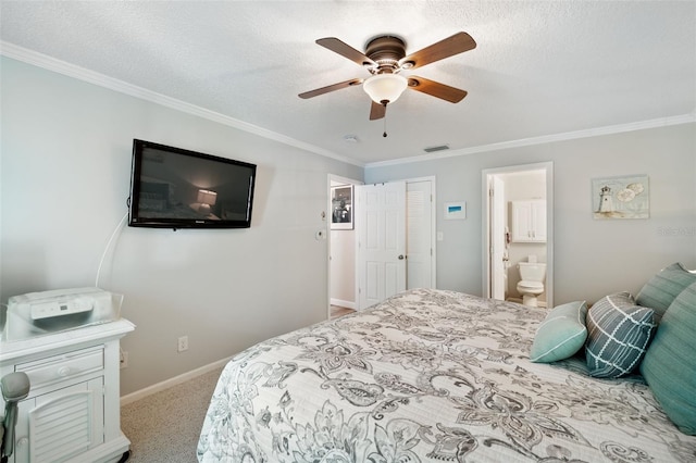 carpeted bedroom with ceiling fan, ensuite bath, ornamental molding, and a textured ceiling