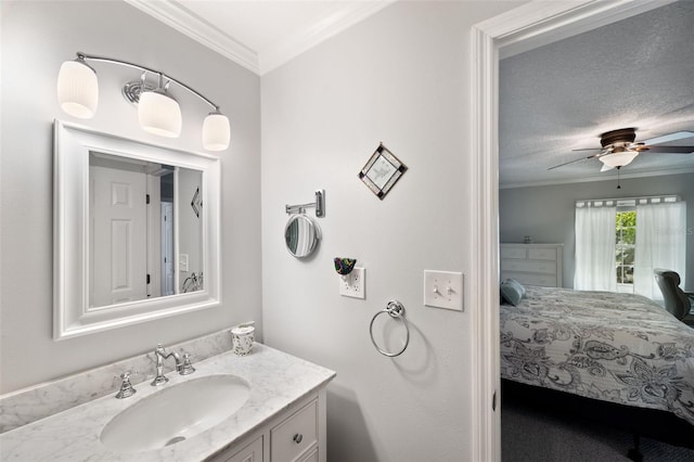 bathroom featuring a textured ceiling, ceiling fan, crown molding, and vanity