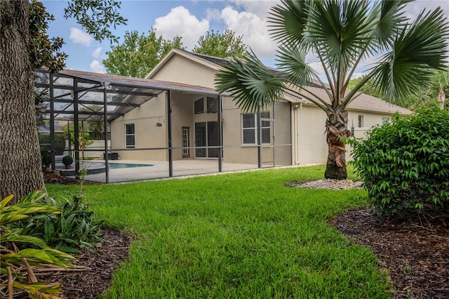 back of house with a lanai, a patio, and a yard