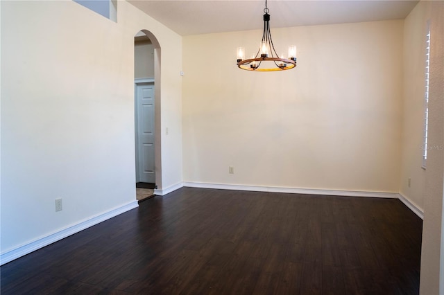 empty room featuring dark hardwood / wood-style floors and a chandelier