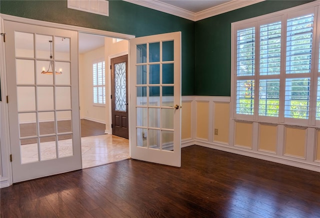 entrance foyer with dark wood-type flooring, ornamental molding, and french doors