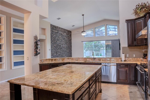 kitchen featuring appliances with stainless steel finishes, light tile patterned floors, a center island, and sink