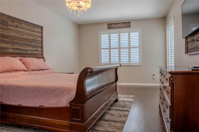 bedroom with a notable chandelier and dark hardwood / wood-style floors