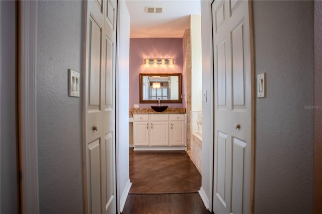 hall featuring dark hardwood / wood-style floors and sink