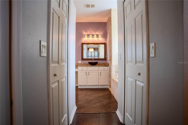 corridor featuring sink and dark wood-type flooring