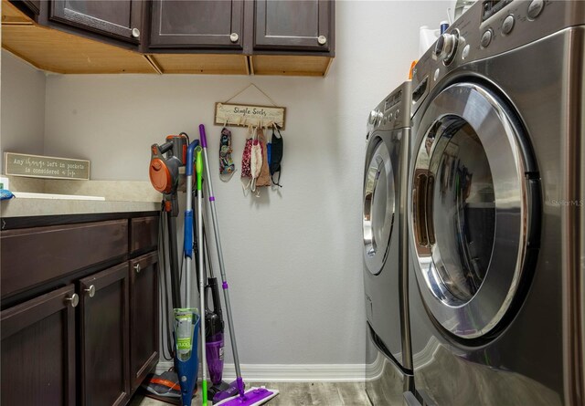 laundry room featuring cabinets, independent washer and dryer, and hardwood / wood-style flooring