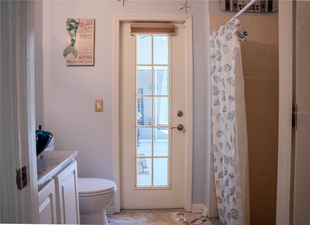 bathroom with tile patterned floors, vanity, a wealth of natural light, and toilet