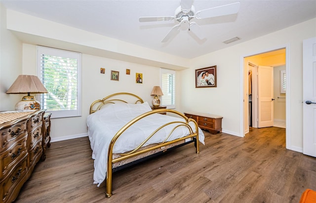 bedroom with multiple windows, dark wood-type flooring, and ceiling fan