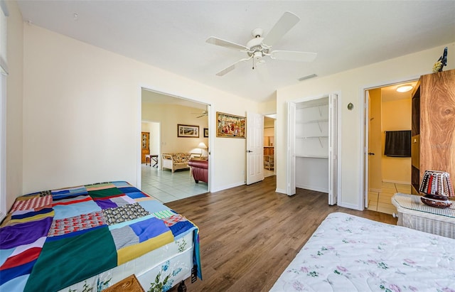 bedroom with light hardwood / wood-style flooring, ceiling fan, and ensuite bathroom