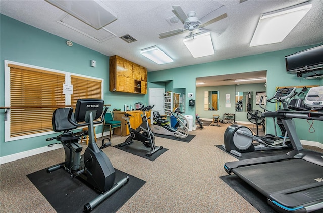 gym with ceiling fan and a textured ceiling