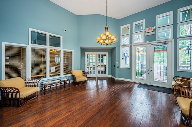 entrance foyer with a high ceiling, hardwood / wood-style flooring, a notable chandelier, and french doors