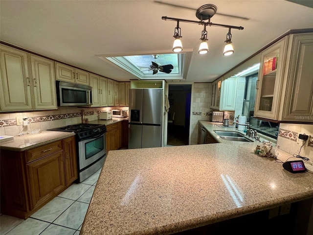 kitchen with pendant lighting, sink, light stone countertops, appliances with stainless steel finishes, and light tile patterned floors