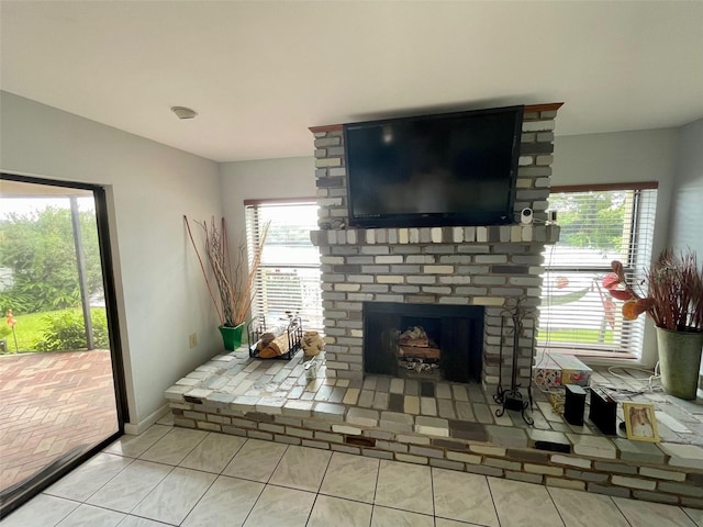 living room with a brick fireplace and light tile patterned floors