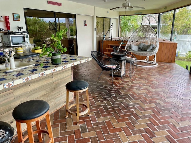 sunroom / solarium featuring ceiling fan