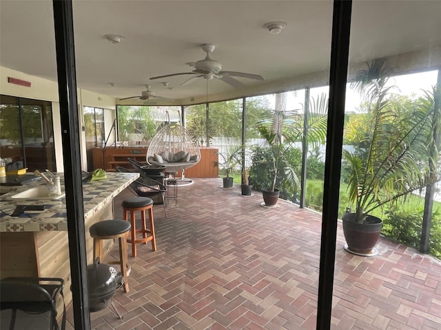 sunroom featuring ceiling fan