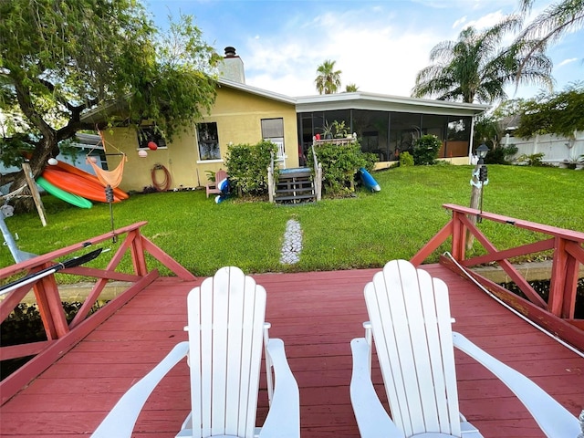 wooden terrace with a sunroom and a lawn