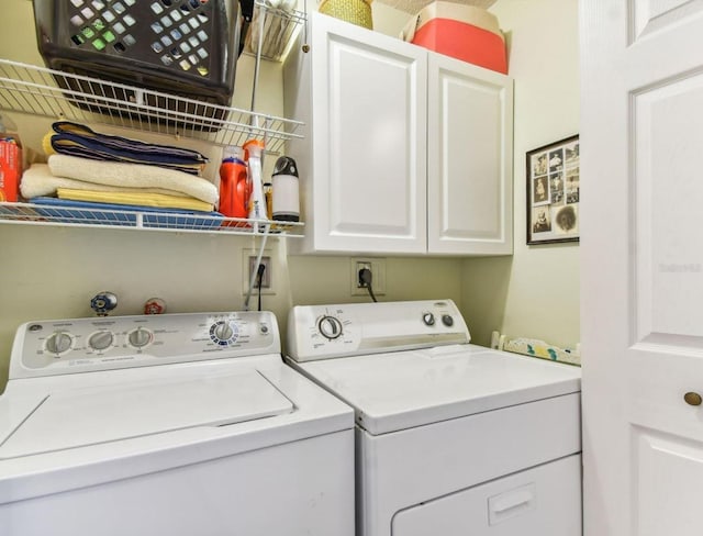 clothes washing area with washing machine and dryer and cabinets