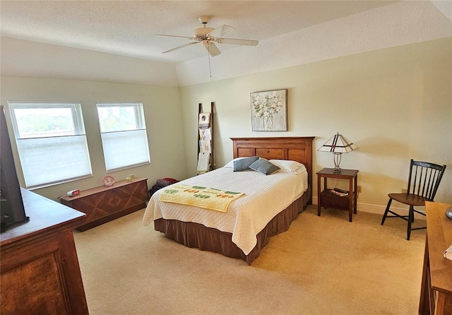 carpeted bedroom with ceiling fan, vaulted ceiling, and a textured ceiling