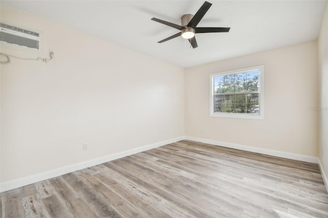 unfurnished room featuring a wall mounted AC, ceiling fan, and light hardwood / wood-style flooring