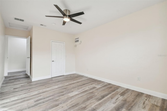 831 Searcy Ave, Sarasota, FL 34237 - unfurnished bedroom with wood finished floors, attic access, a ceiling fan, and a wall mounted air conditioner