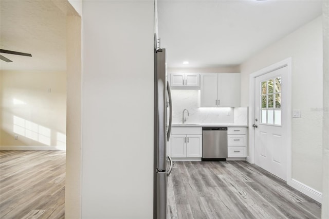 kitchen featuring white cabinetry, sink, ceiling fan, stainless steel appliances, and light wood-type flooring