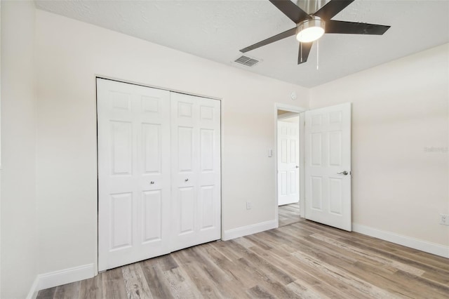 unfurnished bedroom with a closet, light hardwood / wood-style floors, and ceiling fan