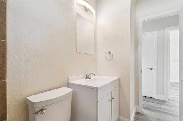 bathroom featuring hardwood / wood-style floors, vanity, and toilet