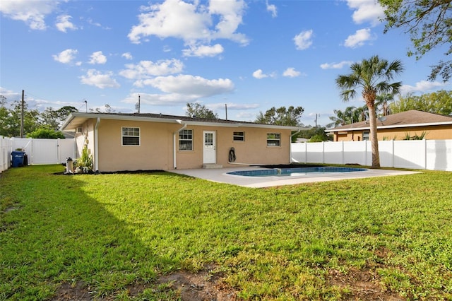 back of house with a lawn, a fenced in pool, and a patio