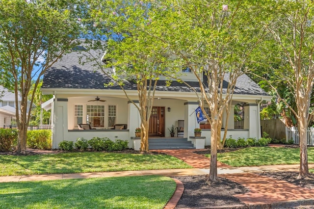 view of front of home with ceiling fan and a front yard