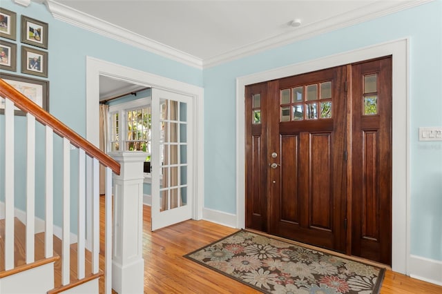 foyer entrance with light hardwood / wood-style floors and ornamental molding