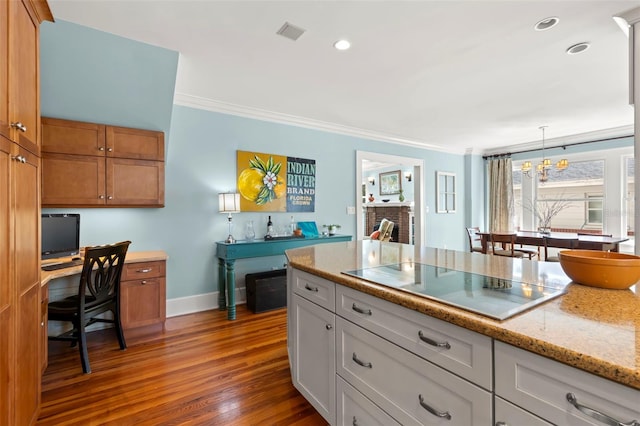 kitchen with dark hardwood / wood-style floors, hanging light fixtures, electric cooktop, white cabinets, and light stone counters