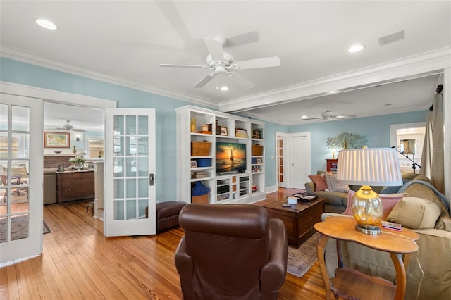 living room featuring light wood-type flooring, ornamental molding, and french doors