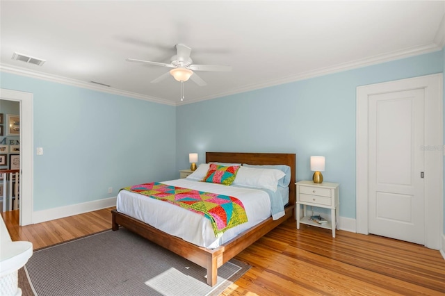 bedroom with ceiling fan, crown molding, and light hardwood / wood-style floors