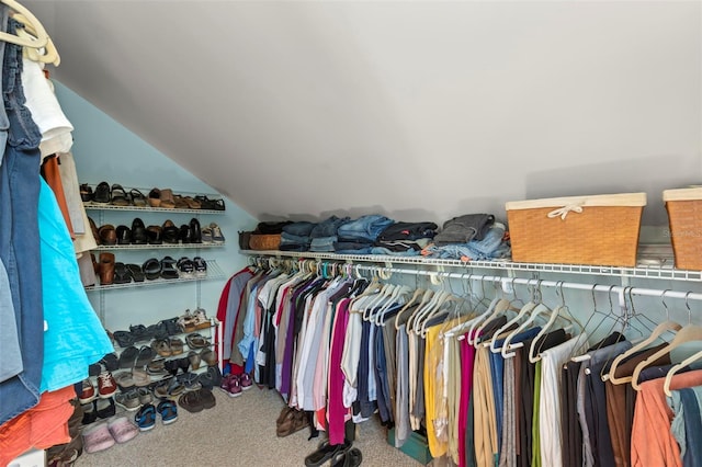 walk in closet featuring carpet floors and vaulted ceiling