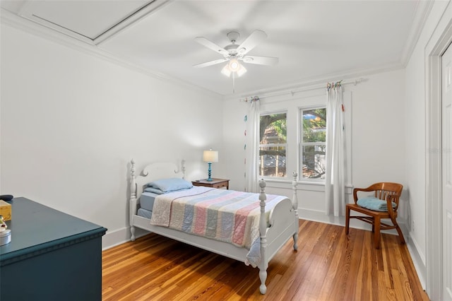 bedroom with ceiling fan, wood-type flooring, and crown molding