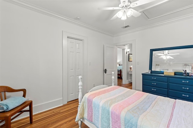 bedroom featuring ceiling fan, a closet, light hardwood / wood-style flooring, and ornamental molding