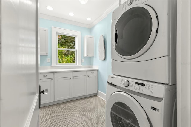 laundry room with stacked washer / dryer, light tile patterned floors, crown molding, and cabinets