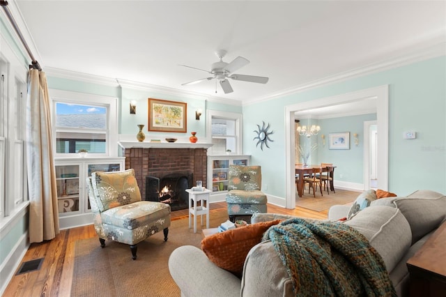 interior space featuring light wood-style flooring, visible vents, baseboards, a brick fireplace, and crown molding